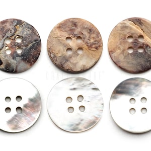 Peut inclure: Six boutons ronds à quatre trous en coquille naturelle. Trois boutons sont marbrés de couleur brune et trois boutons sont blancs avec une finition nacrée.