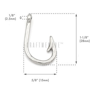 May include: Silver-toned metal hook charm with a 1-1/8 inch (28 mm) length and a 5/8 inch (15 mm) width. The hook is a simple design with a rounded loop and a pointed end.