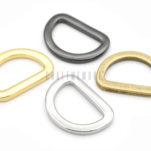 May include: Four D-rings in different finishes: gold, silver, black, and brass. These metal rings are great for attaching to leather straps, bags, or other crafts.