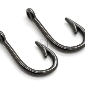 May include: Two black metal hooks with a sharp point. The hooks are about 1 inch long.