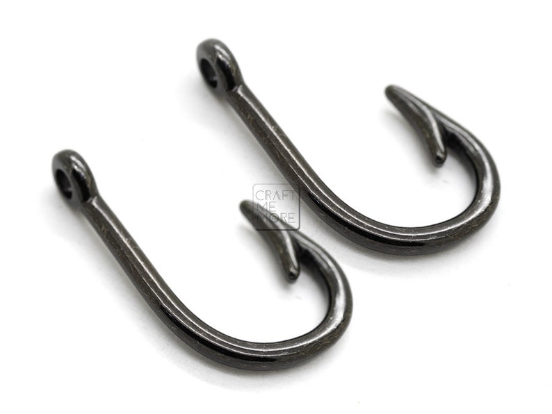 May include: Two black metal hooks with a sharp point. The hooks are about 1 inch long.