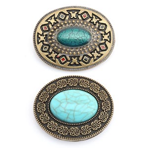 May include: Two oval belt buckles with turquoise-coloured centre stones. The top buckle has a green centre and a gold-coloured metal frame with geometric and red accents. The bottom buckle has a light blue centre and a dark metal frame with a floral design.