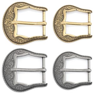 Puede incluir: Dos pares de hebillas de cinturón, un par en latón antiguo y el otro en plata. Ambos pares presentan un diseño floral decorativo.