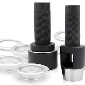 May include: Two black metal grommet punch tools with silver bases and a set of silver grommets.