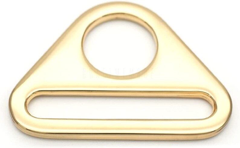 May include: Gold-toned metal triangle-shaped buckle with a round hole and a rectangular opening.