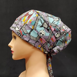 May include: A purple, blue, and pink patterned surgical scrub hat with a tie. The pattern features characters from the Nightmare Before Christmas.