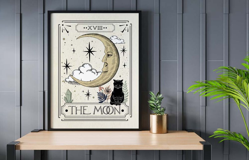 K&ouml;nnte beinhalten: Eine Tarotkarten-Illustration im Vintage-Stil der Karte Der Mond. Die Karte zeigt einen Halbmond mit einem menschlichen Gesicht, eine schwarze Katze und Sterne. Der Text "XVIII. DER MOND." ist auf der Karte gedruckt.