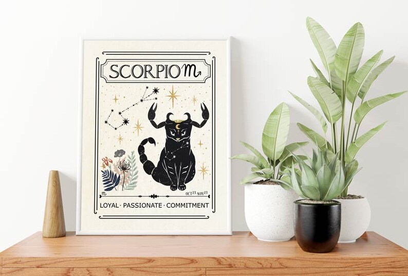 May include: A white framed print with a black cat illustration representing the Scorpio zodiac sign. The print features a constellation, stars, and the text "Scorpio ♏" and "LOYAL - PASSIONATE - COMMITMENT".