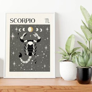 May include: A black and white illustration of a scorpion with a gold crescent moon and stars on a gray background. The text "SCORPIO" and the astrological symbol for Scorpio are at the top of the image.