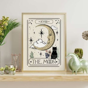 K&ouml;nnte beinhalten: Ein Tarotkarten-Druck im Vintage-Stil mit der Karte Der Mond. Die Karte zeigt einen Halbmond mit einem Gesicht, eine schwarze Katze und Sterne. Der Text "XVIII - THE MOON" ist auf der Karte gedruckt.