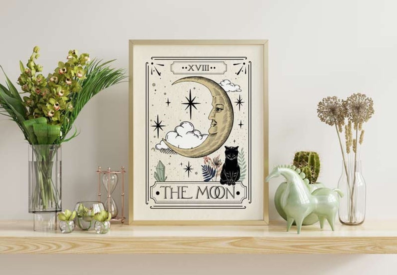K&ouml;nnte beinhalten: Ein Tarotkarten-Druck im Vintage-Stil mit der Karte Der Mond. Die Karte zeigt einen Halbmond mit einem Gesicht, eine schwarze Katze und Sterne. Der Text "XVIII - THE MOON" ist auf der Karte gedruckt.