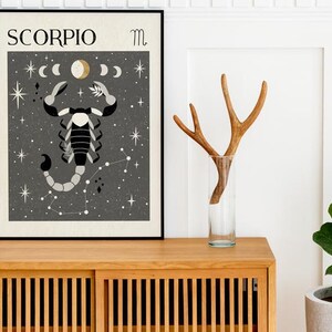 May include: A black framed poster with a gray background featuring a black and white scorpion illustration with the text "SCORPIO" and the astrological symbol for Scorpio.