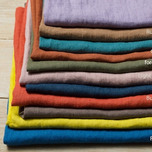 May include: A stack of 11 fabric swatches in various colors, including lavender, rusty brown, teal, cinnamon, forest green, light purple grey, navy blue, burn orange, cocoa, citron, and royal blue.