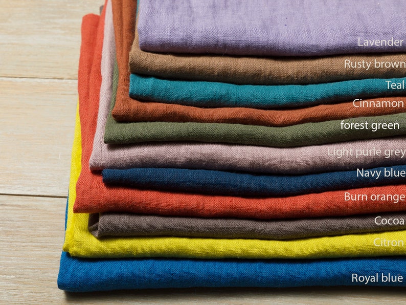 May include: A stack of 11 fabric swatches in various colors, including lavender, rusty brown, teal, cinnamon, forest green, light purple grey, navy blue, burn orange, cocoa, citron, and royal blue.