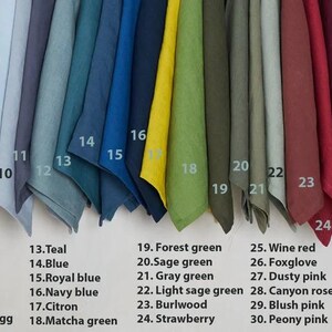 Op de afbeelding: Een kleurstaalkaart met 33 verschillende stofstalen in diverse kleuren, waaronder perzik, gebrande sinaasappel, kaneel, roestbruin, saffraan, cacao, donkergrijs, lichtgrijs, ijsblauw, blauwig grijs, bosbes, grijs eendenei, teal, blauw, koninklijk blauw, marineblauw, citroen, matchagroen, bosgroen, saliegroen, grijsgroen, licht saliegroen, berk hout, aardbei, wijnrood, vingerhoedskruid, stoffig roze, canyonroze, blushroze, pioenroze, stoffig paarsgrijs, paarsgrijs en lavendel.