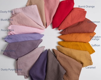 May include: A circular arrangement of folded fabric napkins in various colors labeled as Dusty Peach, Canyon Rose, Fiery Rd, Burnt Orange, Cinnamon, Pumpkin Orange, Saffron, Caramel, Rusty Brown, Cocoa, Plum, Dusty Purple Grey, Purple Grey, Lavender, Peony Pink, Blush Pink, Dusty Pink.