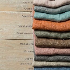 May include: A stack of 12 fabric swatches in various colors, including light grey, pale rose, grey blue, aquamarine, natural orange, desert sage green, mocha brown, woodrose, graphite, light natural, blue, and white.