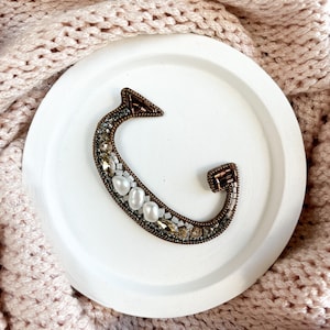 Broche de cuentas con la letra G en bronce