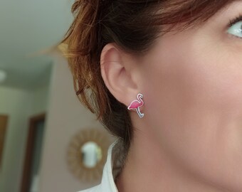 May include: Pink flamingo stud earrings. The earrings are small and feature a pink flamingo design with a white outline.