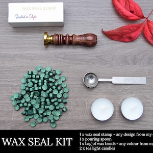 May include: A wax seal kit featuring a wooden handle stamp, a silver pouring spoon, green wax beads, and two tea light candles. The kit includes a box with the text "WAX SEAL STAMP" and "Invited in Style".