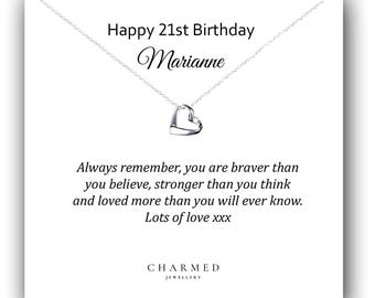 Op de afbeelding: Een witte kaart met een zilveren ketting met een dubbele hart hanger. De kaart heeft de tekst "Happy 21st Birthday Marianne" en een bericht dat luidt: "Onthoud altijd dat je dapperder bent dan je denkt, sterker dan je denkt en meer geliefd dan je ooit zult weten. Heel veel liefde xxx" en de tekst "CHARMED JEWELLERY".