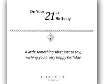Könnte beinhalten: Ein silbernes Armband mit einem Herz-Anhänger auf einer weißen Karte mit dem Text "On Your 21st Birthday. A little something silver just to say, wishing you a very happy birthday. CHARMED JEWELLERY."