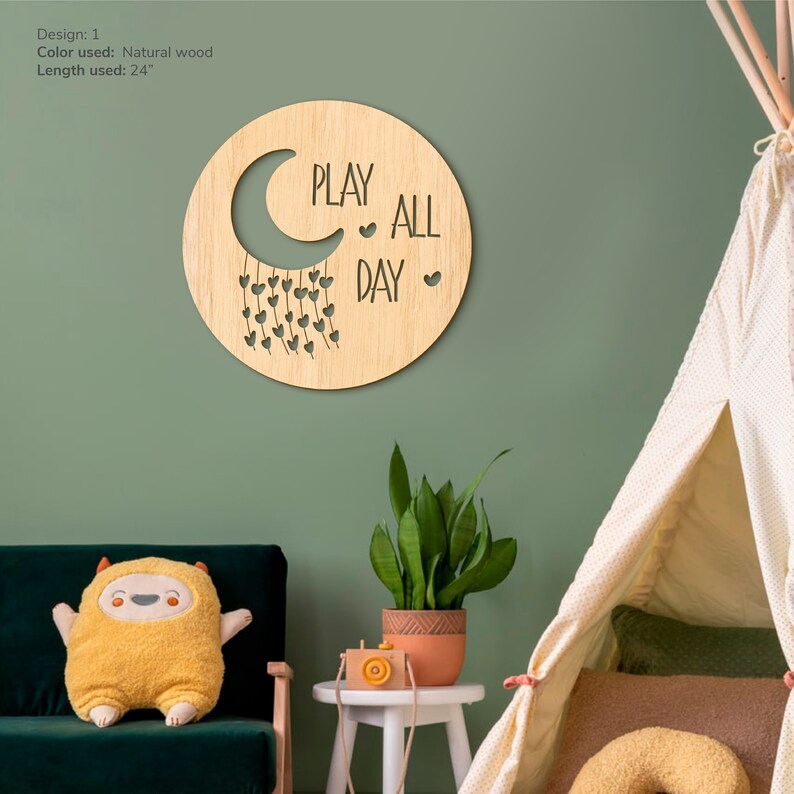 May include: A wooden wall decor with a crescent moon and the text "PLAY ALL DAY" with hearts hanging from the moon. The decor is 24 inches in length.