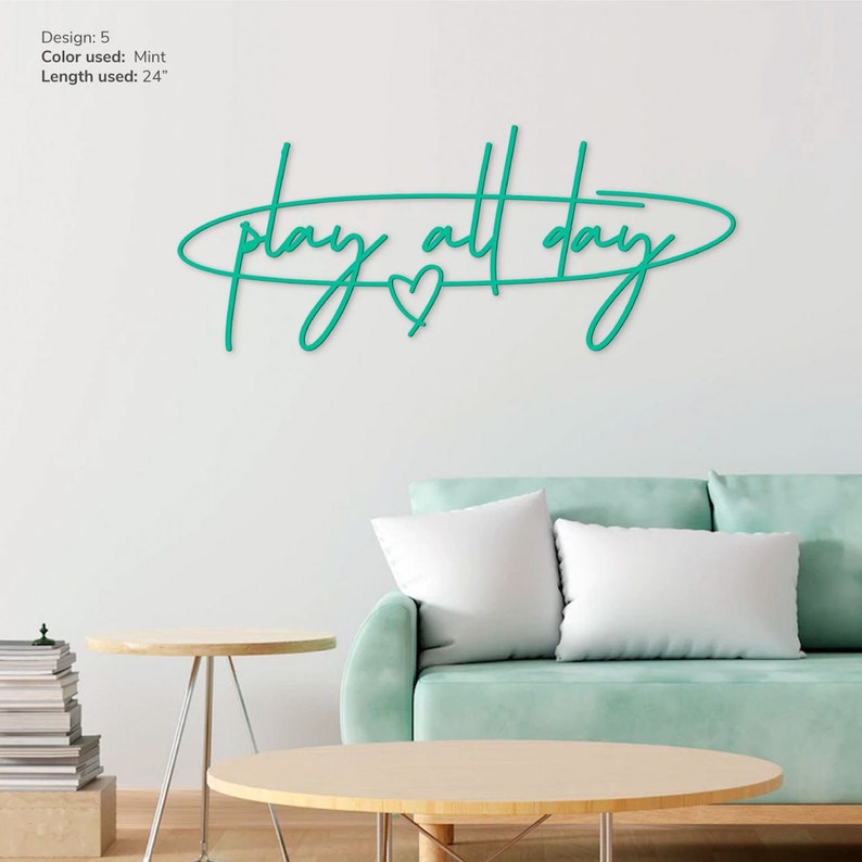 May include: Mint green metal wall art with the text "play all day" in a cursive font. A small heart is included in the design.