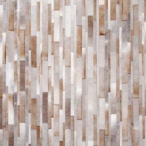 Top view of a Striped patchwork cowhide rug in taupe, gray, beige and cream natural hair-on-hide leather.