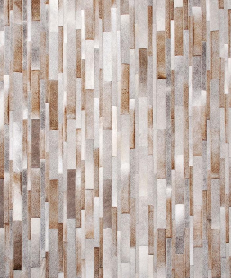 Top view of a Striped patchwork cowhide rug in taupe, gray, beige and cream natural hair-on-hide leather.