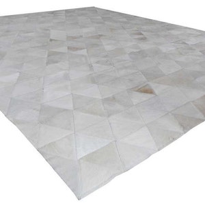 White Triangles Patchwork Cowhide Rug. The Kata cowhide area rug in cream, off-white hide. Available in custom and standard siezes 8x10ft, 9x12ft, 10x13ft. Free shipping to USA and Canada
