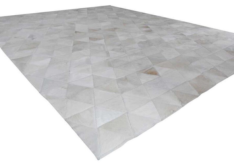White Triangles Patchwork Cowhide Rug. The Kata cowhide area rug in cream, off-white hide. Available in custom and standard siezes 8x10ft, 9x12ft, 10x13ft. Free shipping to USA and Canada