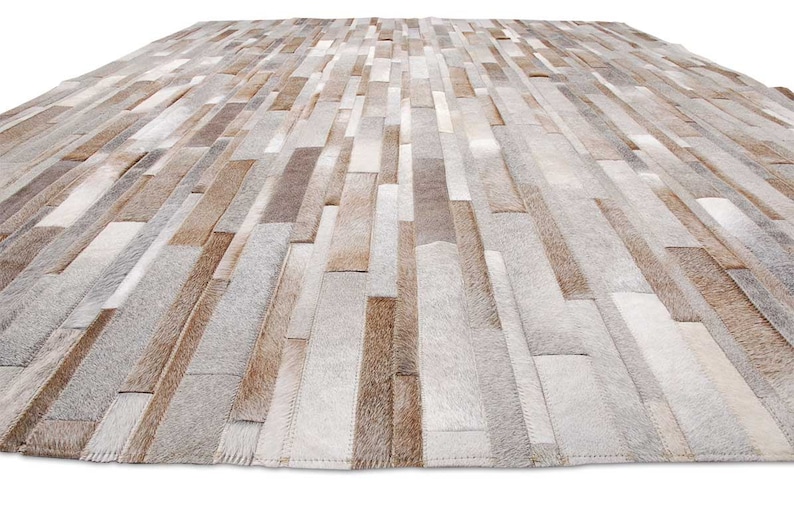 Floor view of a Taupe, Beige, Gray Stripes Patchwork Cowhide Rug.