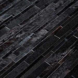 Detail of a Black Stripes Patchwork Cowhide Rug by Shine Rugs. A cowhide rug suitable for any kind of home decor. Bright and shiny natural black hair. Custom sizes, free shipping to US and Canada.