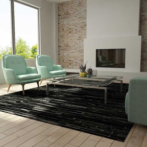 Sunny living room with a Black Stripes Patchwork Cowhide Rug by Shine Rugs. A cowhide rug suitable for any kind of home decor. Bright and shiny natural black hair. Custom sizes, free shipping to US and Canada.