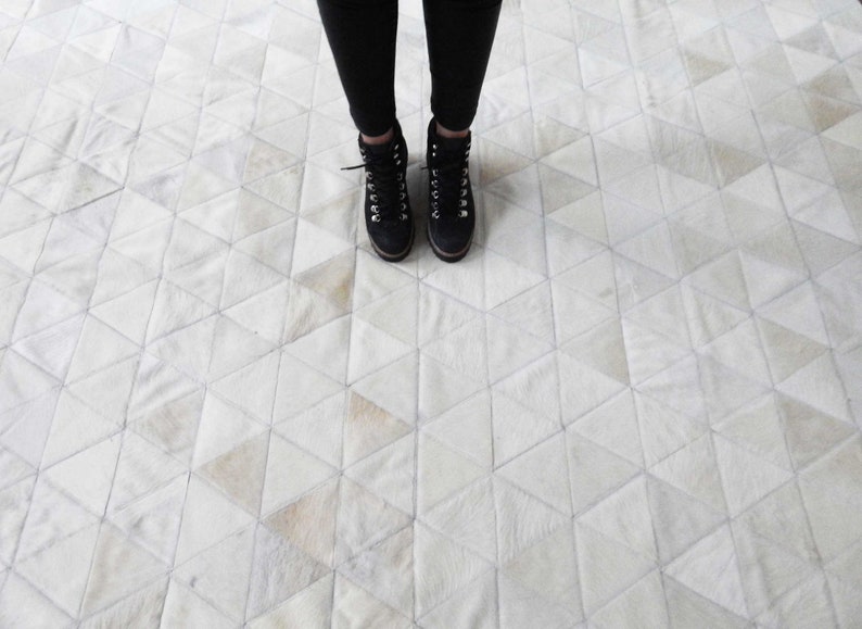 White Triangles Patchwork Cowhide Rug. The Kata cowhide area rug in cream, off-white hide. Available in custom and standard siezes 8x10ft, 9x12ft, 10x13ft. Free shipping to USA and Canada