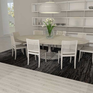 Open plan dining room with a Black Stripes Patchwork Cowhide Rug by Shine Rugs. A cowhide rug suitable for any kind of home decor. Bright and shiny natural black hair. Custom sizes, free shipping to US and Canada.