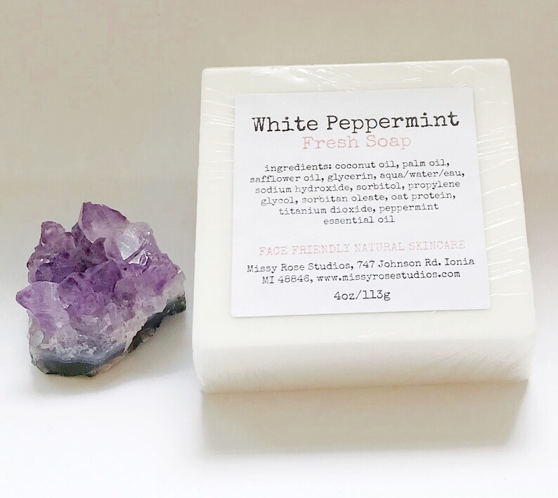 May include: A white bar of "White Peppermint Fresh Soap" with a label listing ingredients. Next to the soap is a cluster of purple amethyst crystals. The soap is 4oz/113g.