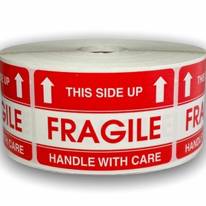 May include: Roll of red and white fragile shipping labels with the text "This Side Up" and "Handle With Care" and an arrow pointing upwards.