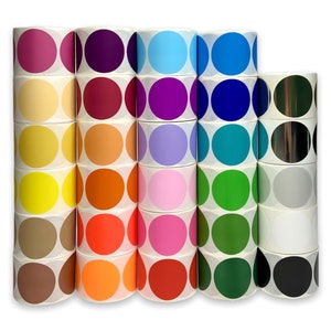 May include: A collection of round stickers in a variety of colors, including pink, orange, green, and blue. The stickers are arranged in stacks, showcasing a spectrum of hues. Each sticker has a solid color and is on a white backing.