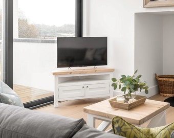 Mueble de TV esquinero con estante para multimedia y puerta estilo shaker. Fabricado a mano en cualquier tamaño y color, con tablero rústico grueso y base pintada de blanco.