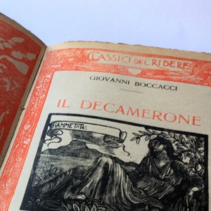 May include: A vintage book cover with a red and white border. The title is "Il Decamerone" by Giovanni Boccaccio. The cover features a black and white illustration of a woman sitting on a rock with a mountain in the background.