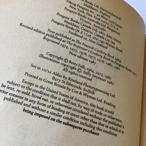 May include: A black and white image of a book's copyright page. The text includes the title "The Peacock Cookery Book", the author "Betty Falk", and the publisher "Penguin Books".