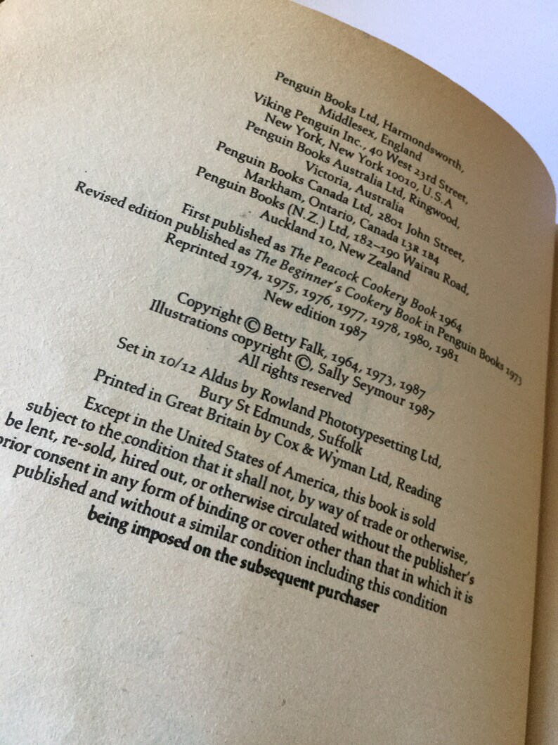 May include: A black and white image of a book's copyright page. The text includes the title "The Peacock Cookery Book", the author "Betty Falk", and the publisher "Penguin Books".