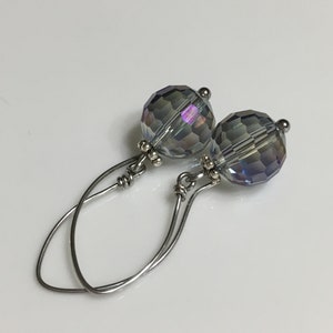 May include: A pair of silver dangle earrings with iridescent gray faceted glass beads.