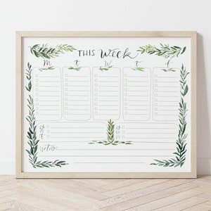 May include: A printable weekly planner with a simple design featuring a white background with black text and green watercolour foliage. The planner is labelled "This Week" and includes columns for each day of the week: Monday, Tuesday, Wednesday, Thursday, Friday, Saturday, and Sunday.