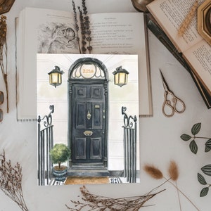May include: A watercolor painting of a black door with a brass door knocker and the number "221B" above it. The door is flanked by two black wrought iron gates and two black lanterns.