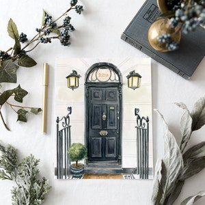 May include: A watercolor painting of a black door with a brass door knocker and the number 221B above it. The door is flanked by two black wrought iron gates and two black lanterns.
