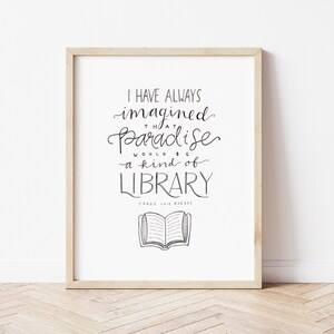 May include: A framed print with a black and white quote that reads "I have always imagined that paradise would be a kind of library."  The quote is attributed to Jorge Luis Borges.  A simple black and white illustration of an open book is below the quote.