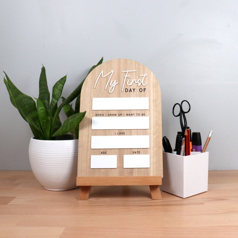 My First Day of School whiteboard photo prop for children. Celebrate your little one's first day of school with this interactive photo prop that lets your children write down their details to look back on in the future. Wooden photo prop with 3D acrylic title and whiteboard sections to fill in.